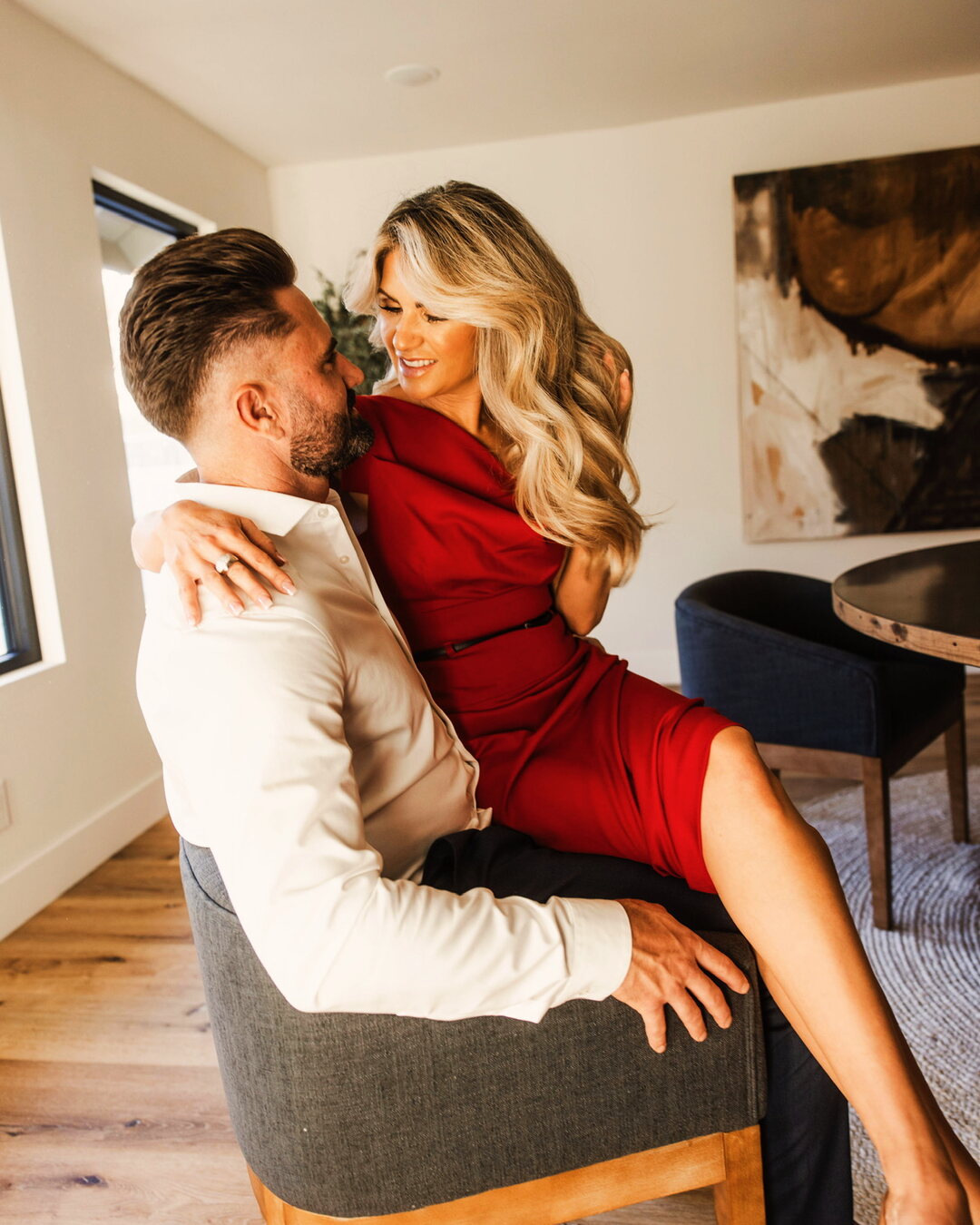 A couple relaxed and close at home in warm light, the kind of ordinary day that starts feeling like a life again.
