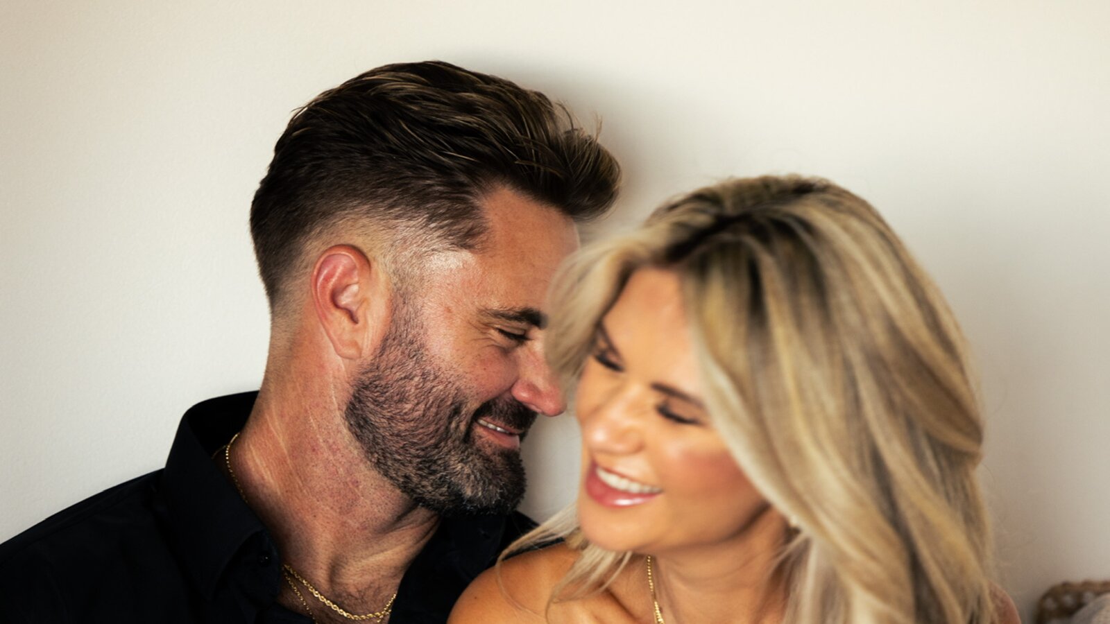 Mark and Bree, foreheads close, sharing a quiet laugh